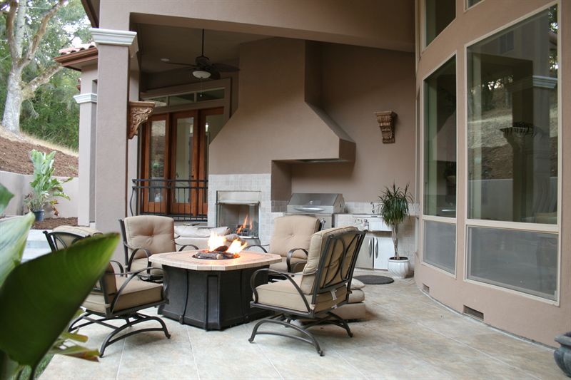Covered outdoor living area with fireplace, fire table and seating
