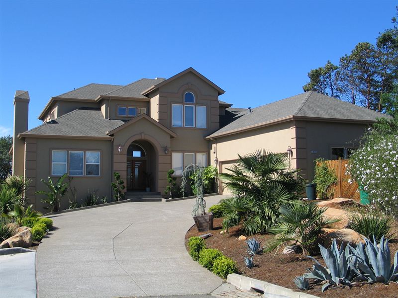 Two-story custom home with landscaped drive and drought planting